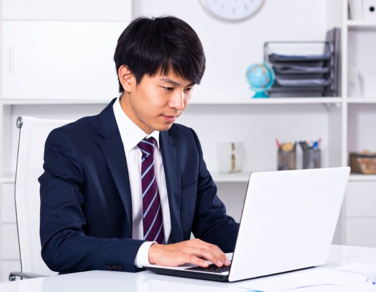ノートパソコンに向かうスーツ姿の男性
