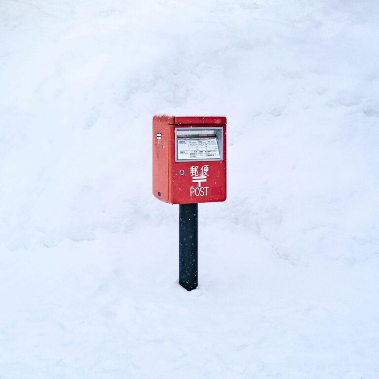 雪の中に立つ赤い郵便受け