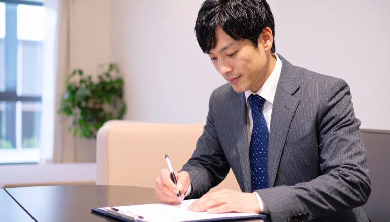 書類を確かめるスーツ姿の男性
